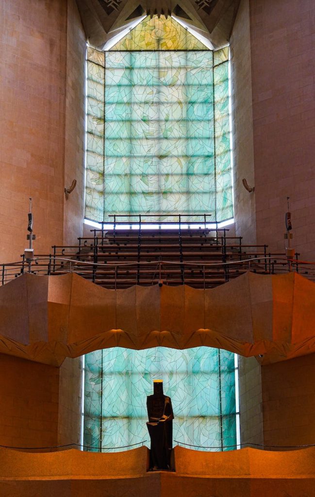 stained glass windows and metal religious statue inside la sagrada familia in barcelona spain